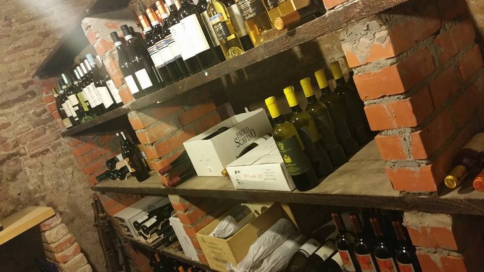 La cantina con volte in mattoni e scaffali di bottiglie