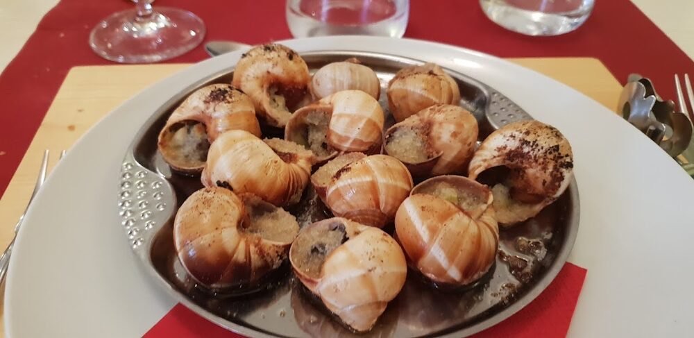 Lumache alla parigina nel guscio, sul tavolo con la tovaglietta rossa